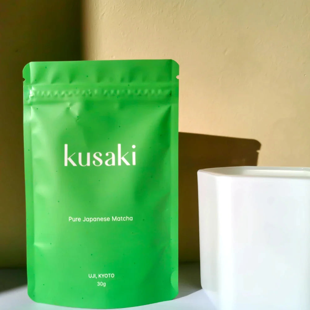 Kusaki matcha green tea next to a candle