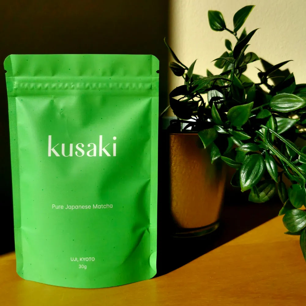 Kusaki matcha green tea pouch in front of a plant
